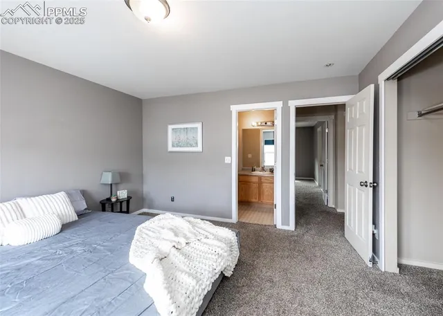 a spacious bedroom with a bed and a refrigerator