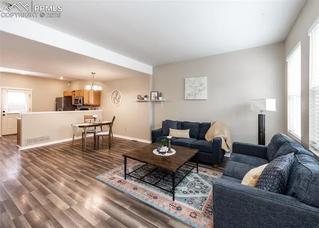 a living room with furniture wooden floor and a table
