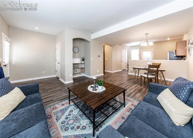 a living room with furniture and a wooden floor