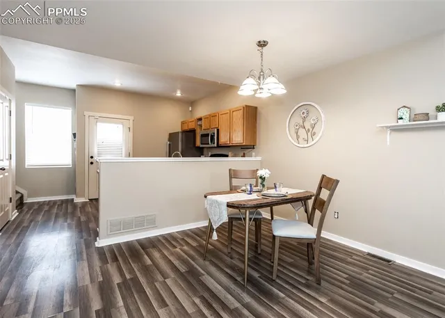 a view of a dining room with furniture a chandelier and wooden floor