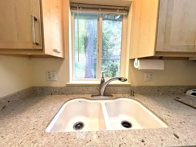 a bathroom with a granite countertop sink and a bathtub