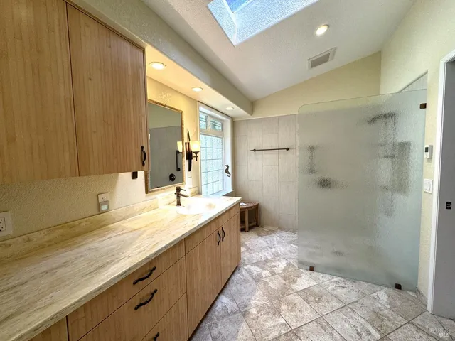 a bathroom with a granite countertop sink a toilet and shower
