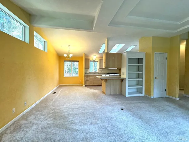 a view of a big room with wooden floor and windows