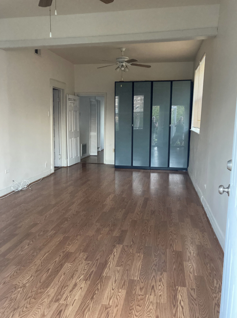 1109 South Racine Avenue Chicago, IL 60607 - Photo 8 of 29 a view of an empty room with wooden floor and a window