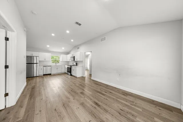 a view of a kitchen with a sink and wooden floor