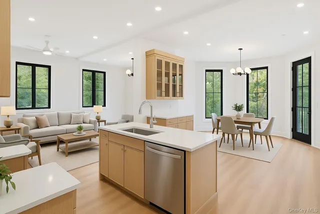 a living room with stainless steel appliances granite countertop furniture a couch a sink a dining table and chairs