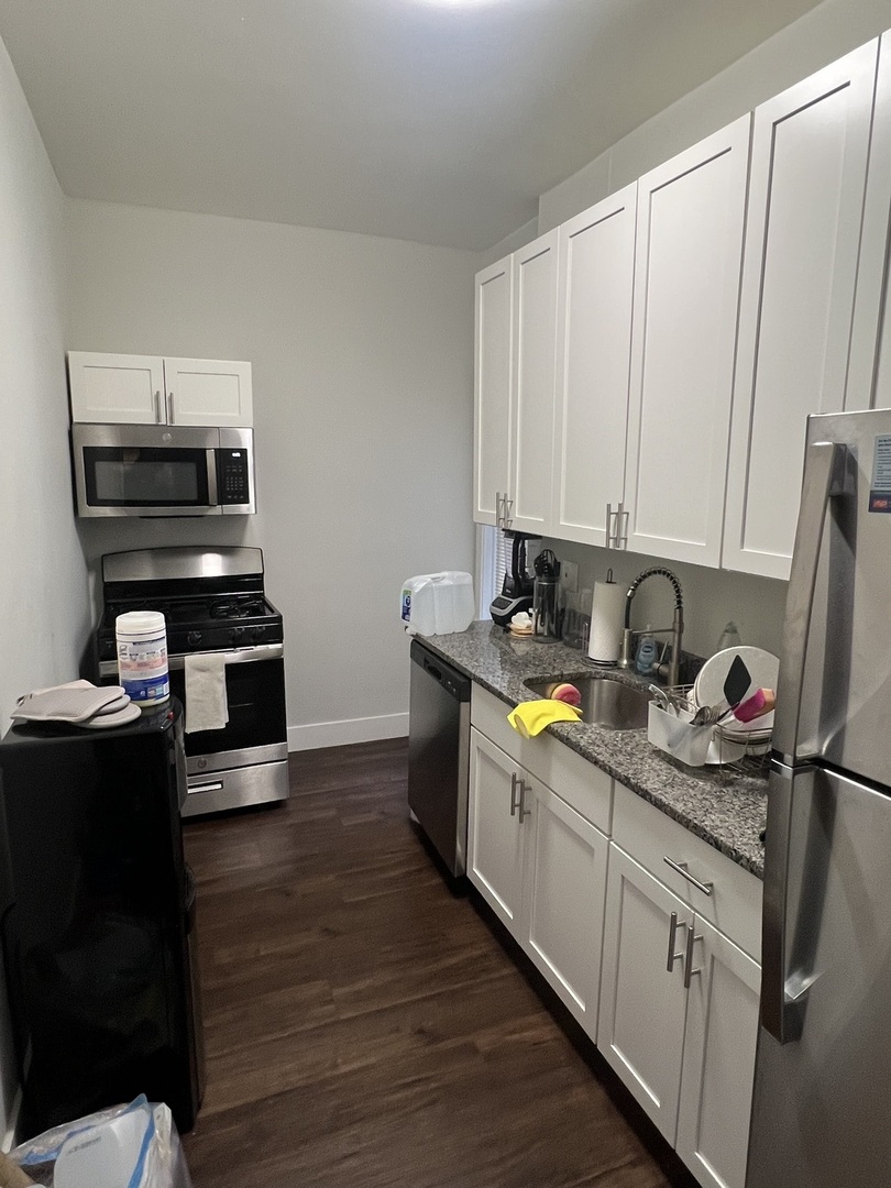 7661 North Sheridan Road Chicago, IL 60626 - Photo 12 of 19 a kitchen with stainless steel appliances a stove a sink a refrigerator and wooden cabinets