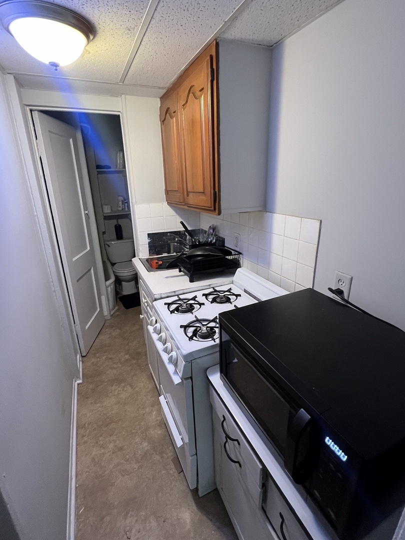 7661 North Sheridan Road Chicago, IL 60626 - Photo 16 of 19 a kitchen with a stove and a refrigerator