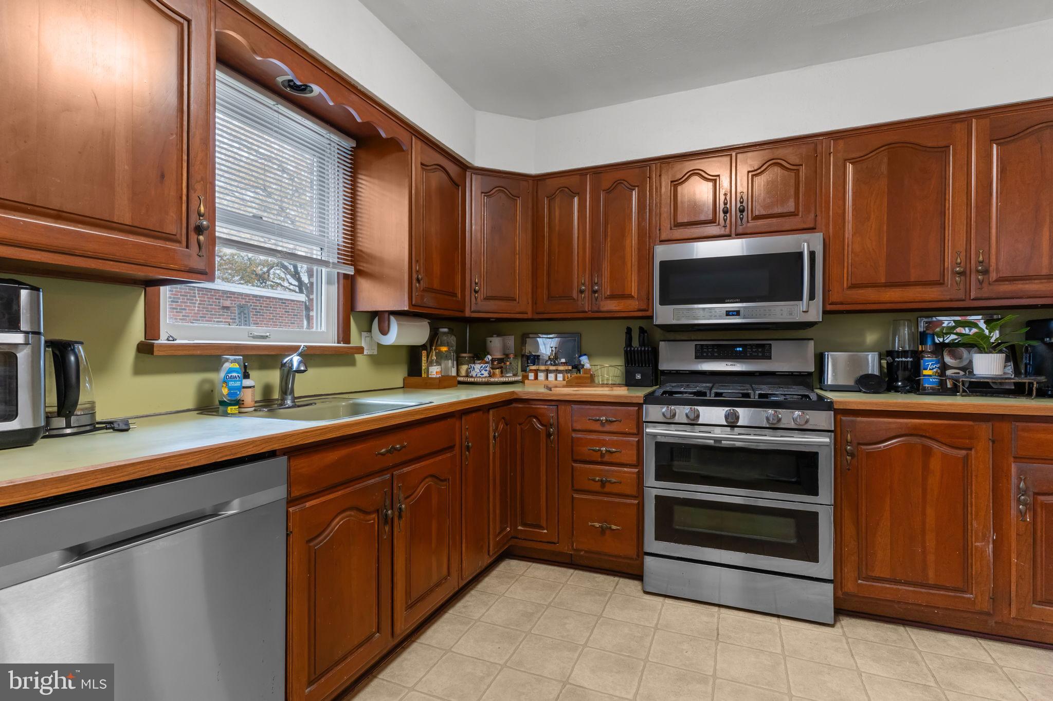 1117 Surrey Road Philadelphia, PA 19115 - Photo 6 of 24 a kitchen with stainless steel appliances granite countertop a stove microwave and sink