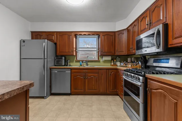 a kitchen with granite countertop a refrigerator stove top oven and sink