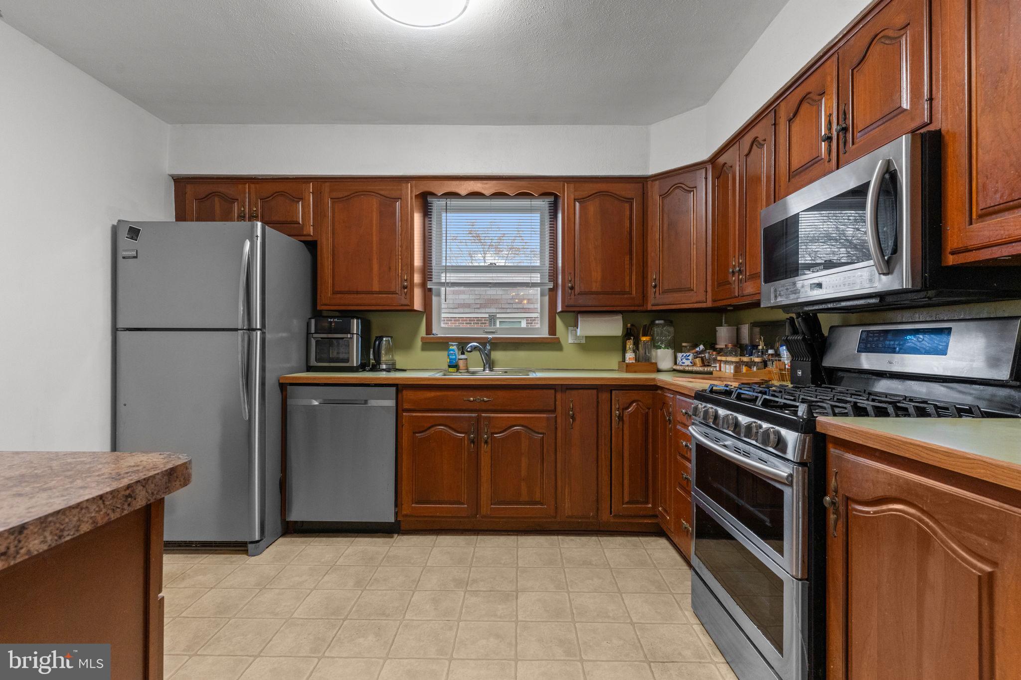 1117 Surrey Road Philadelphia, PA 19115 - Photo 7 of 24 a kitchen with granite countertop a refrigerator stove top oven and sink
