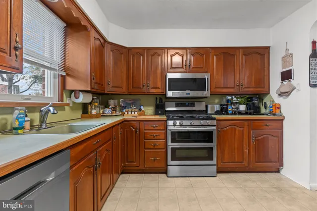 a kitchen with stainless steel appliances a stove a sink and a microwave