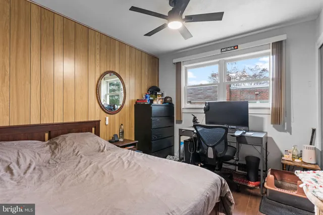 a bedroom with a bed a computer on the desk and a chair