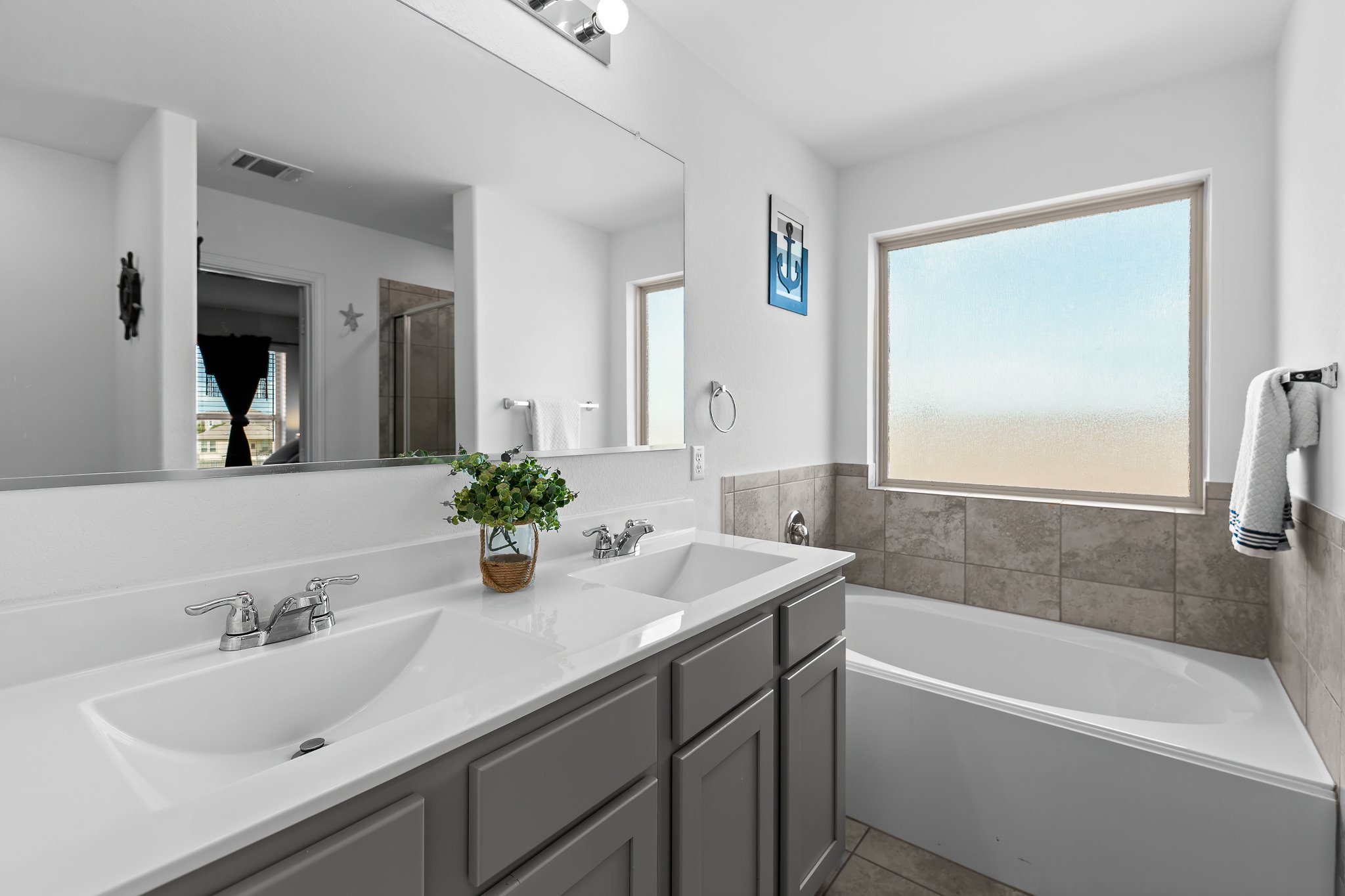 576 Greatest Gift Way Jarrell, TX 76537 - Photo 28 of 37 Dual vanity sinks provide ample space in this bright, well-appointed primary bathroom.