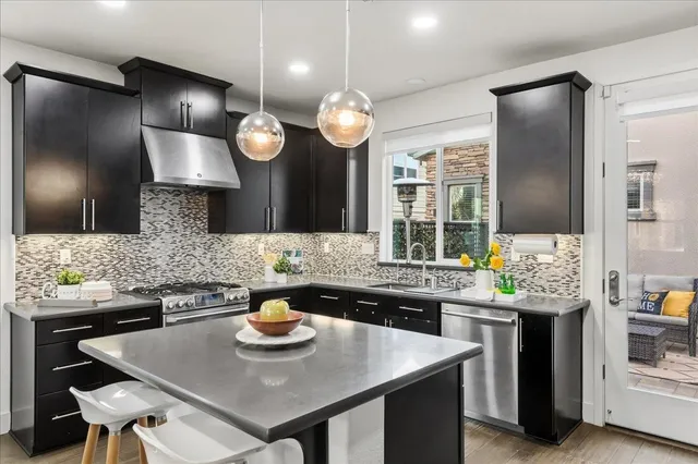 a kitchen with a sink a stove and chairs
