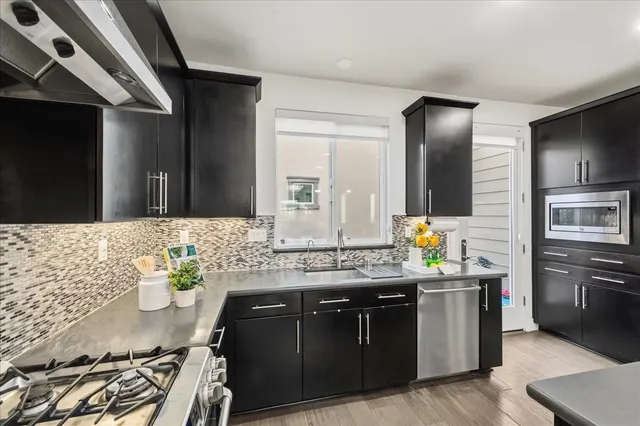 a kitchen with stainless steel appliances granite countertop a sink stove and refrigerator