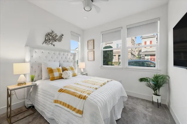 a bedroom with a large bed and a potted plant