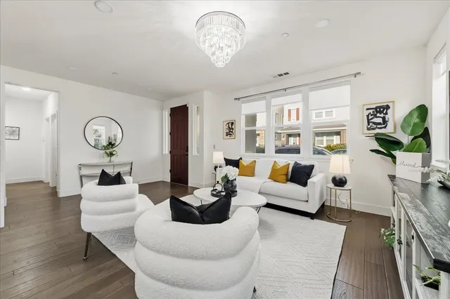 a living room with furniture chandelier and a table