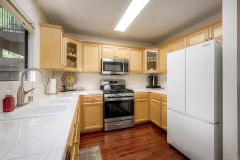 a kitchen with granite countertop a refrigerator stove and sink