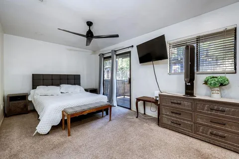 a bedroom with a bed a flat screen tv and a couch