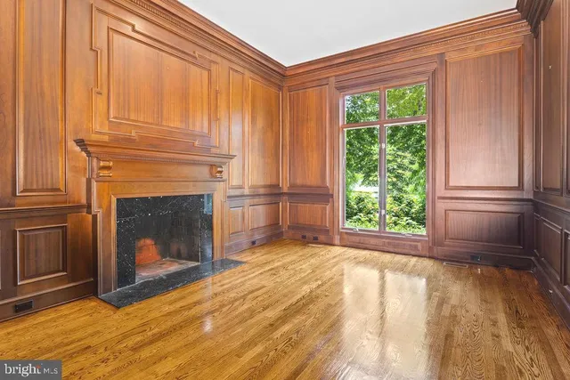 a view of a livingroom with wooden floor and a fireplace