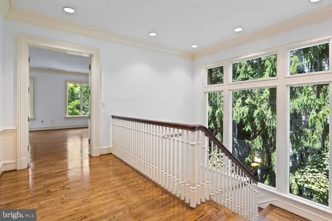an empty room with wooden floor a fireplace and windows