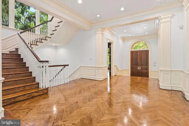 a view of an empty room with wooden floor and windows