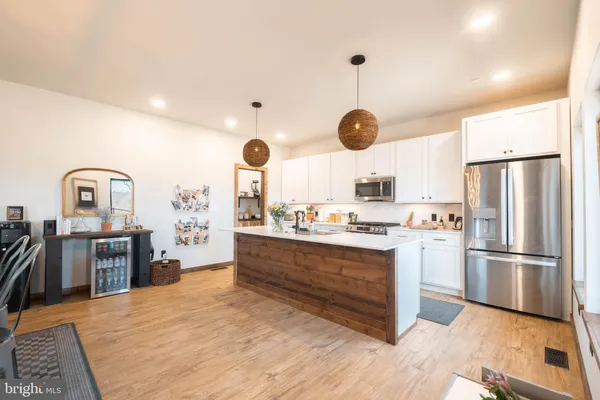 a kitchen with stainless steel appliances granite countertop a refrigerator a stove and a sink