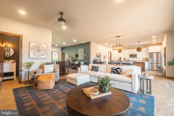 a living room with furniture kitchen view and a chandelier