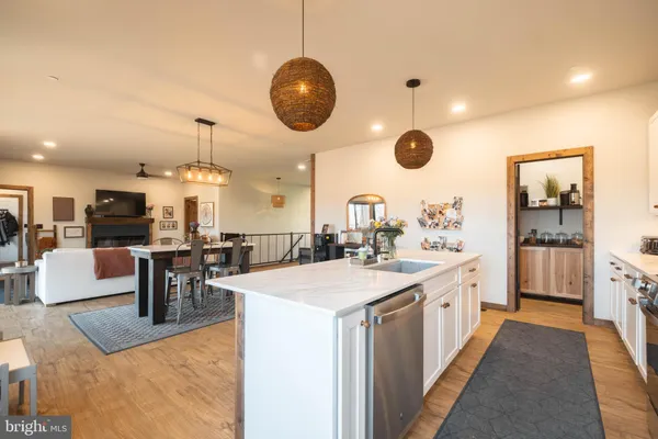 a kitchen with stainless steel appliances kitchen island a table and chairs in it