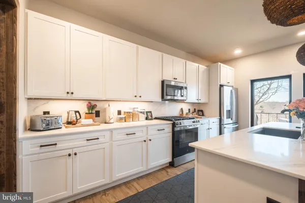 a kitchen with kitchen island granite countertop white cabinets and white appliances