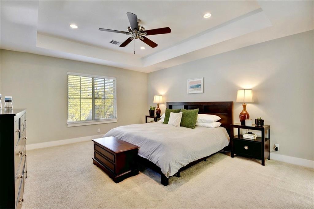 701 East 49th Street, Unit B Austin, TX 78751 - Photo 12 of 27 Bedroom featuring light colored carpet, ceiling fan, a tray ceiling, and recessed lighting