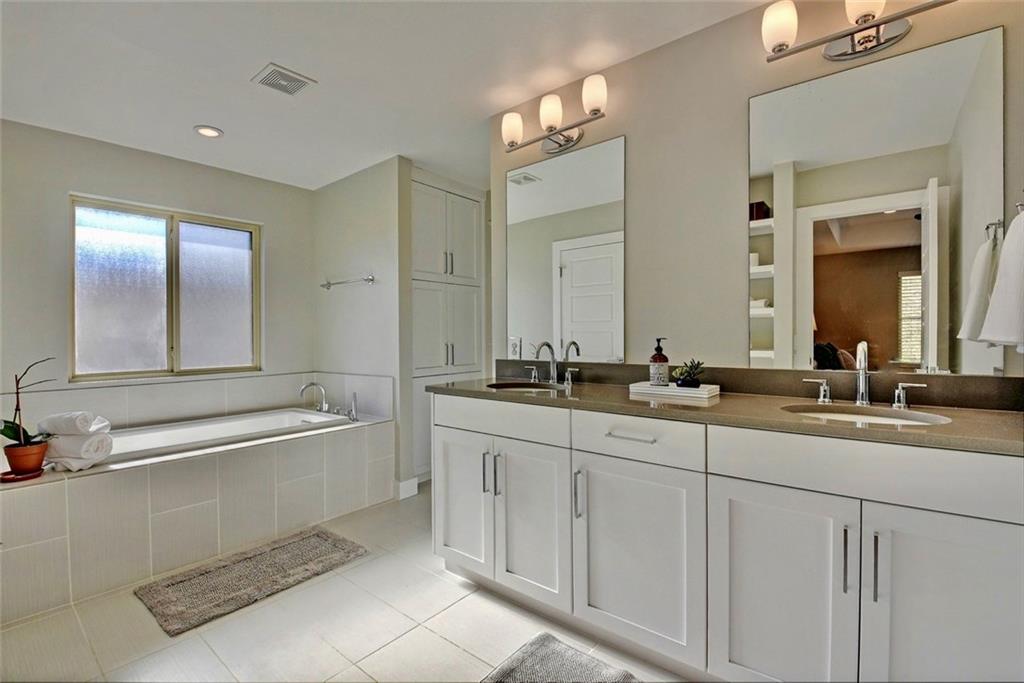 701 East 49th Street, Unit B Austin, TX 78751 - Photo 15 of 27 Full bath with double vanity, healthy amount of natural light, a garden tub, and light tile patterned floors