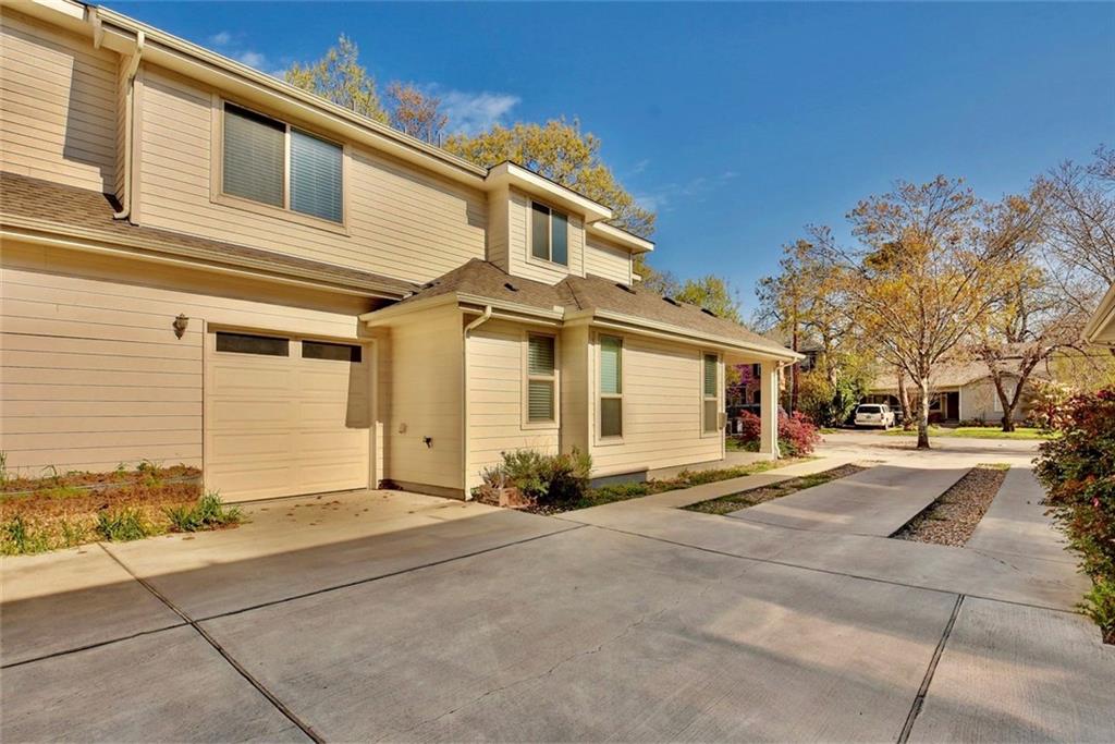 701 East 49th Street, Unit B Austin, TX 78751 - Photo 23 of 27 View of front of property featuring an attached garage, driveway, and a shingled roof