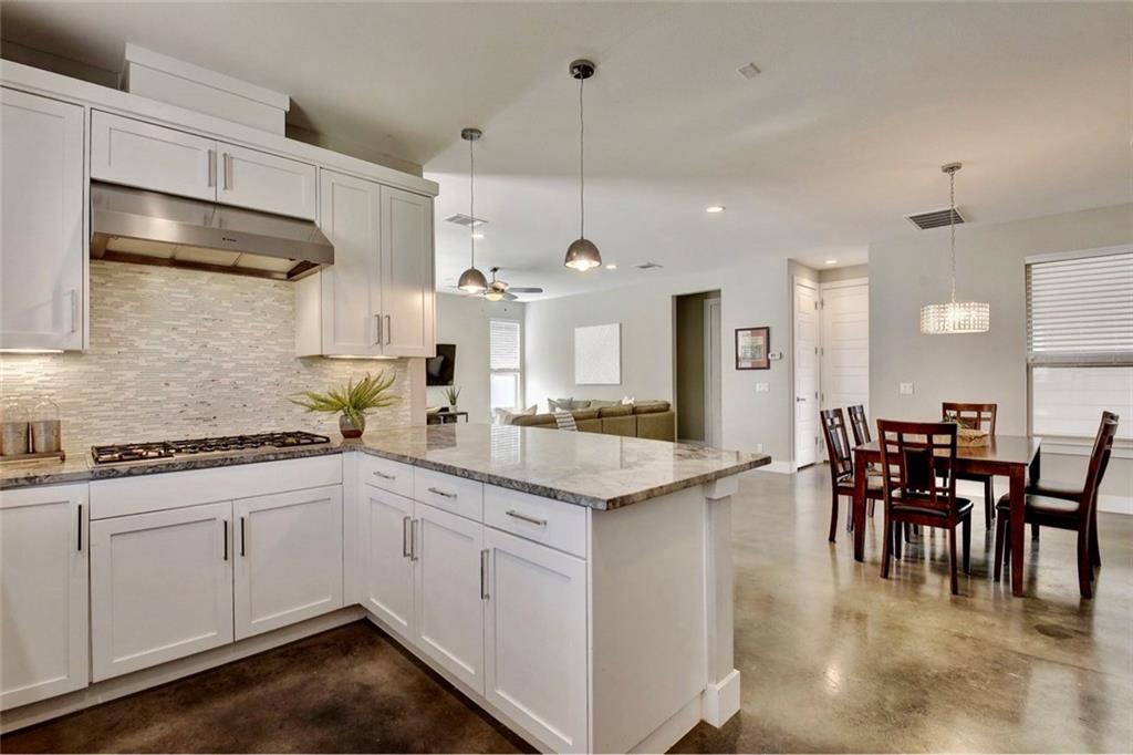 701 East 49th Street, Unit B Austin, TX 78751 - Photo 3 of 27 Kitchen with concrete floors, pendant lighting, a peninsula, and light stone countertops