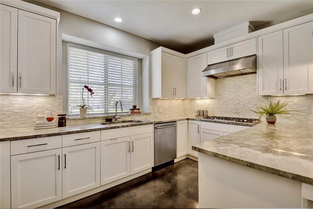 701 East 49th Street, Unit B Austin, TX 78751 - Photo 6 of 27 Kitchen featuring finished concrete flooring, white cabinets, tasteful backsplash, stainless steel appliances, and recessed lighting
