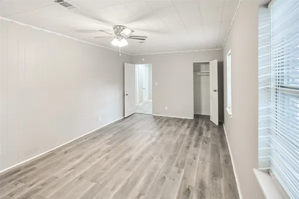 a view of a room with wooden floor and a window