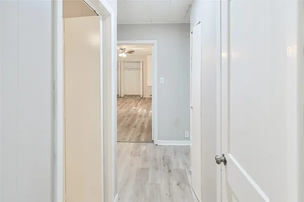 an empty room with wooden floor and fan