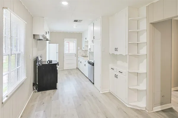 a view of a hallway with wooden floor and windows