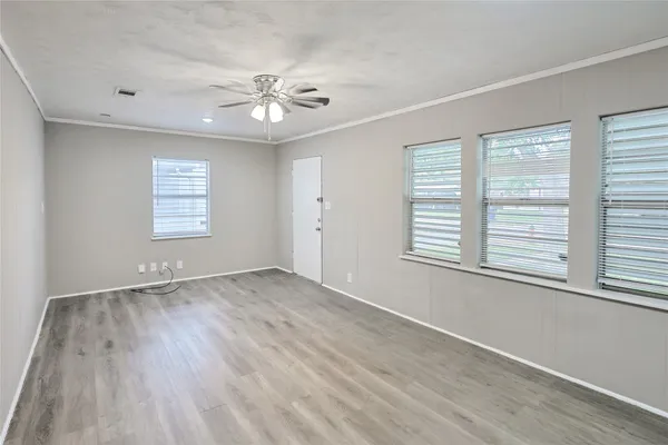 an empty room with a window and a ceiling fan