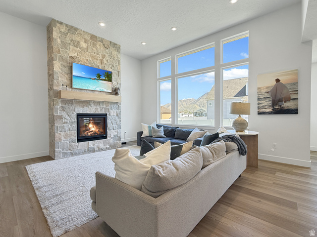 916 Rocky Mountain Way Elk Ridge, UT 84651 - Photo 10 of 54 Living room featuring a fireplace, light wood-style flooring, recessed lighting, and a textured ceiling