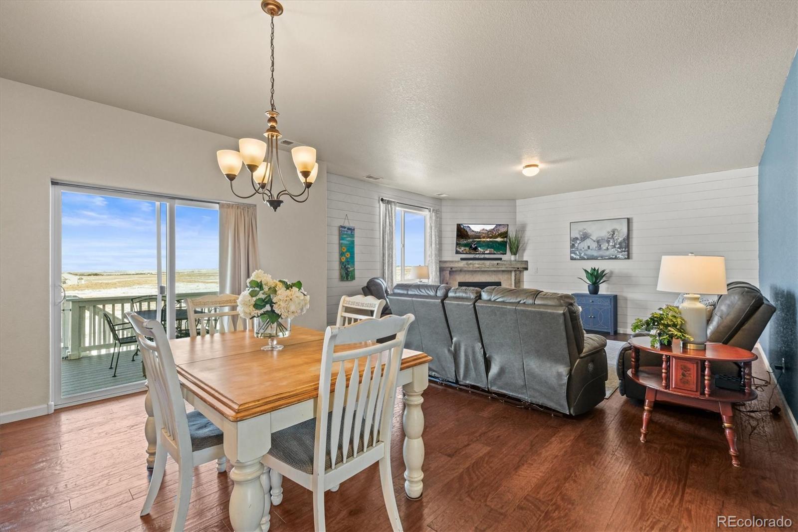 5774 Desert Inn Loop Elizabeth, CO 80107 - Photo 2 of 37 a view of a dining room with furniture a chandelier and wooden floor