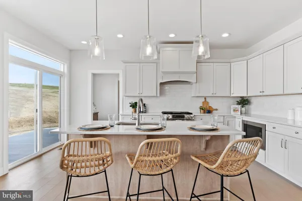 a kitchen with stainless steel appliances granite countertop a table chairs stove a refrigerator and cabinets