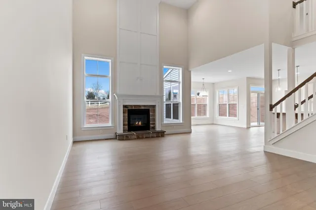 an empty room with wooden floor and fireplace
