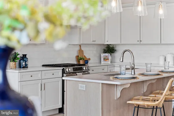 a kitchen with a sink a faucet a stove and cabinets