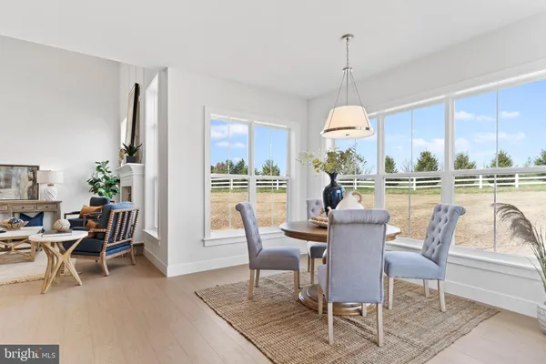 a dining room with furniture a chandelier and kitchen view