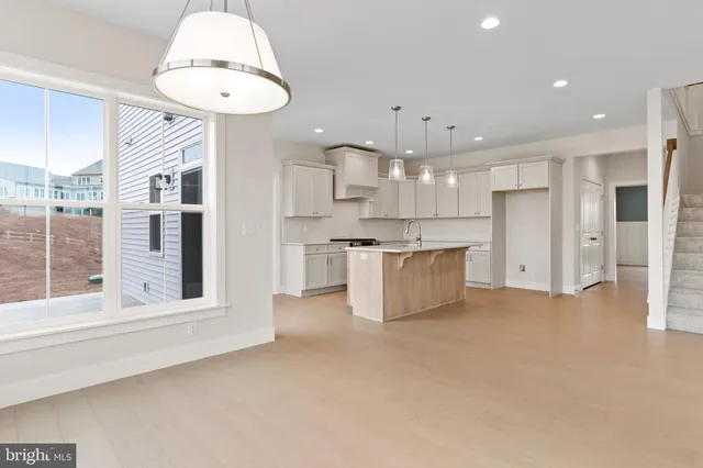 a view of kitchen with stainless steel appliances granite countertop cabinets and a chandelier