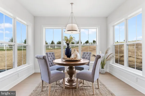 a dining room with furniture a chandelier and wooden floor