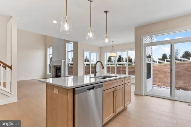a kitchen with stainless steel appliances granite countertop a sink a oven and a view of living room