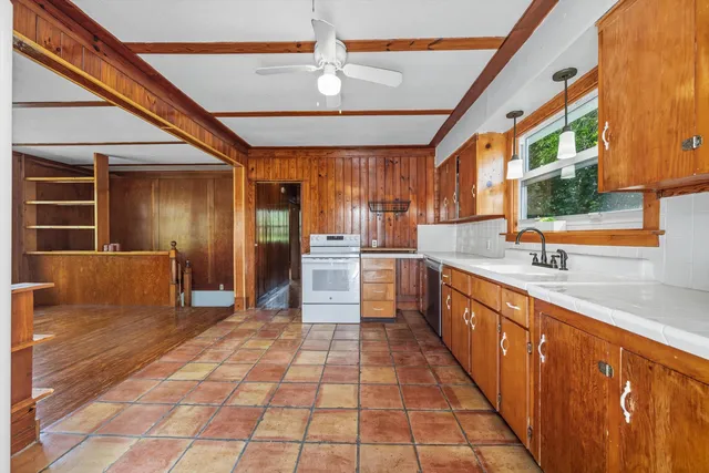 a large kitchen with stainless steel appliances granite countertop a refrigerator and a sink